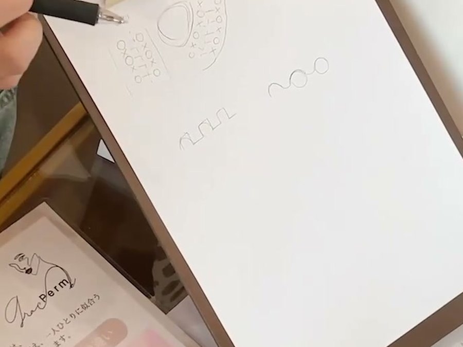 紙に図を描いて設計を説明している様子